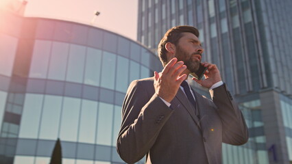Smart ceo communicating smartphone outside office close up. Businessman calling