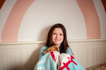 A girl's laughter fills the room as she clutches a plush leopard, against the playful backdrop of a...