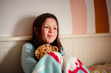 A girl's laughter fills the room as she clutches a plush leopard, against the playful backdrop of a...