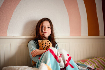 A girl's laughter fills the room as she clutches a plush leopard, against the playful backdrop of a...