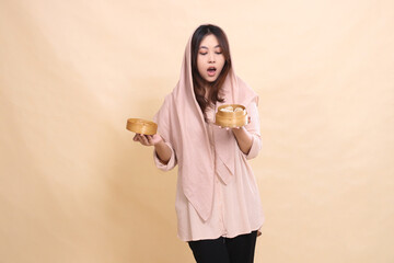 Asian hijab woman stood shocked when she saw dimsum her hand opened the lid of the wooden bowl containing dimsum. beautiful Muslim women for culinary, business, food