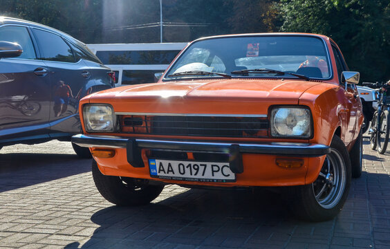 Orange two-door coupe subcompact car Isuzu Gemini 1st gen (PF50), 1978 which is an analogue of the Opel Kadett displayed at the exhibition of retro cars