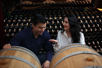 young couple is talking and smiling while choosing wine - 769182439