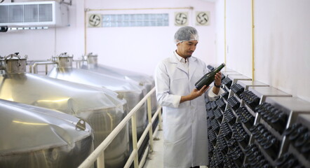 Winemaker working in modern large winery factory drink industry  and he testing wine in a wine factory warehouse - 769182695