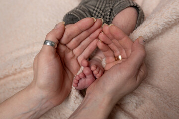 feet newborn baby in a white cloth in my mother's hands	