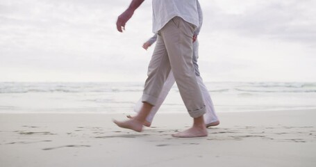 Couple, holding hands and legs on sand, bonding and vacation or holiday, relaxing and romance. People, freedom and support in marriage, calm and travel to outdoors, ocean and love in partnership