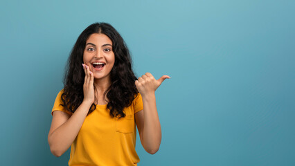 Surprised woman pointing thumb, looking to side