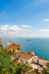 Fototapeta na wymiar Italian landscape. Old houses with tiled roofs on a background of blue sea and sky