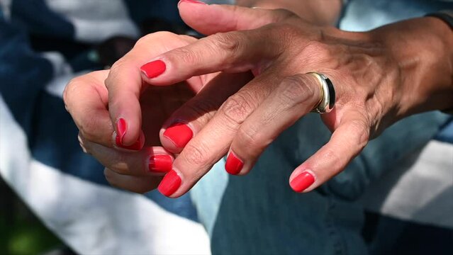 nervous woman's hands touching her nails
