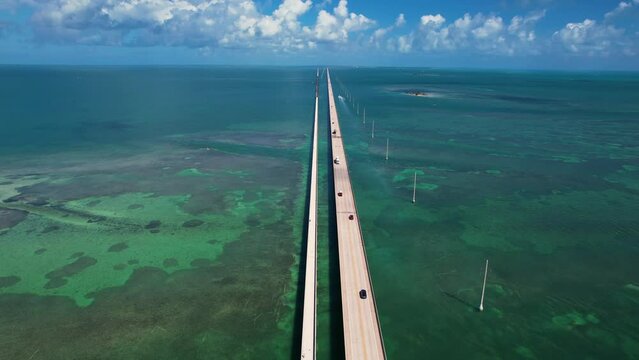 7 Mile Bridge Florida Keys Aerial View. Fly Over American Bridge Over Turquoise Green Ocean To Bright Blue Sky.
