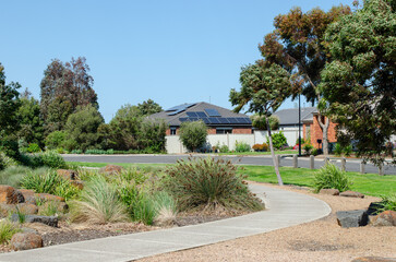 Suburban Landscape: Curving Pathway Through a Modern Neighborhood Park. A footpath leads to some residential Australian homes in the suburb.