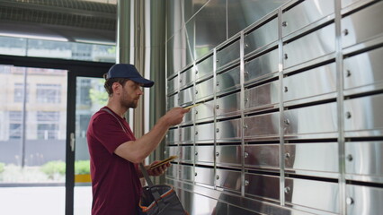 Mailman putting post correspondence into lockers. Closeup silver post containers
