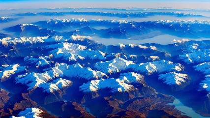 Foto op Plexiglas aerial view of a mountain range, possibly taken from an airplane. The mountains are covered in snow and ice, creating a stunning and majestic landscape © Iwantto