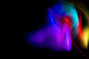 Abstract rainbow on textured black background. Long exposure. Light painting photography.