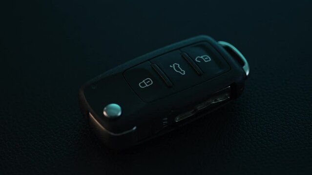 Car Key Rotates on Dark Surface. Close-up, shallow dof.