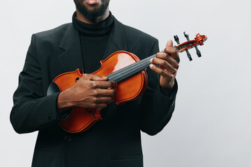 African American man in suit holding violin on white background, elegant musician with string...