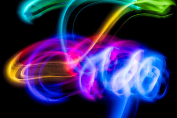 Abstract colorful irregular lines on black background and wall texture. Long exposure. Light painting photography.
