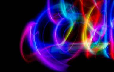 Abstract colorful irregular lines on black background and wall texture. Long exposure. Light painting photography.