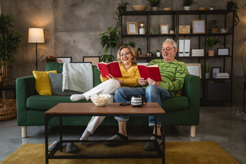 Obraz premium mature senior couple man and woman husband and wife read book at home