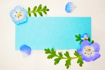 レースのホワイトバックに青い瑠璃唐草の花と葉を添えた春イメージのタイトルフレームのモックアップ