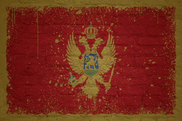 colorful painted big national flag of montenegro on a massive brick wall