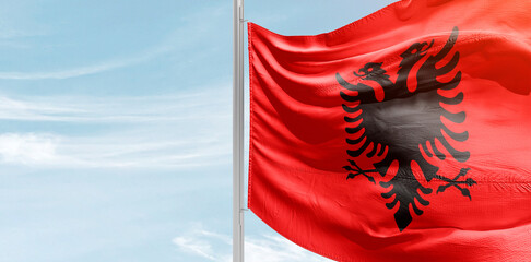 Albania national flag with mast at light blue sky. - obrazy, fototapety, plakaty