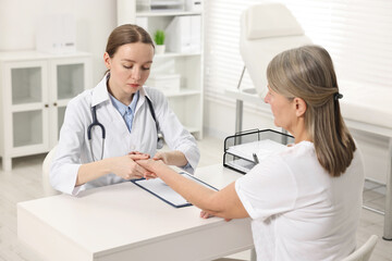 Arthritis symptoms. Doctor examining patient's wrist in hospital
