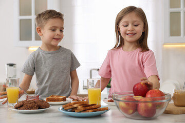 Obraz na płótnie Canvas Little children having breakfast at table in kitchen