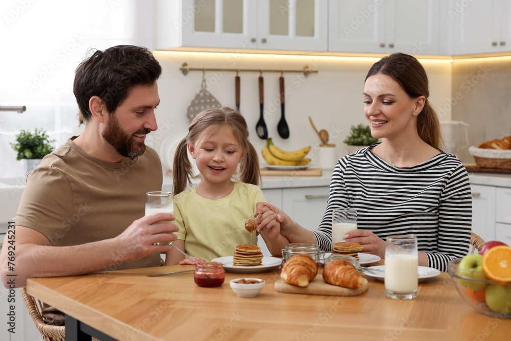 Sticker Happy family having breakfast at table in kitchen