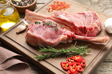 Fresh tomahawk beef cuts and spices on wooden table