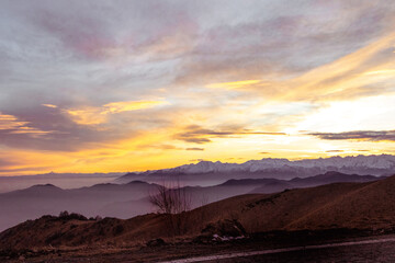 Sunset in the mountains. Orange sky and indigo shades. Suggestive sunset from Mottarone mountain,...
