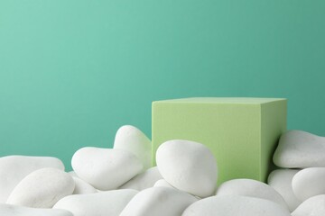 Fototapeta na wymiar Presentation for product. Light green cube podium and white pebbles on color background. Space for text