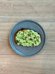 Avocado toast with za'atar seasoning on a wood background