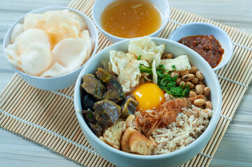 Bubur Daging Spesial or Special Meat Porridge contains white rice with side dishes of grilled beef slices