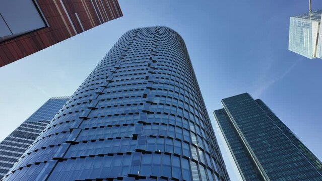 Low-angle pov of La Defense modern skyscrapers, Paris. First-person walking view