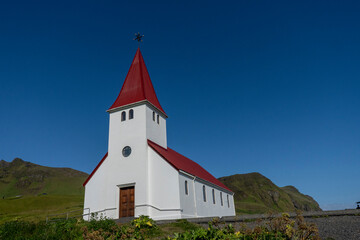 Vik i Myrdal Church, little white church with a bright red roof which sits atop a hill above Vík, Iceland. Built in 1929.