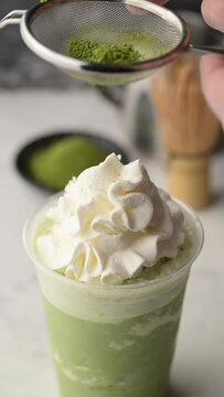 sifting matcha powder on matcha frappe