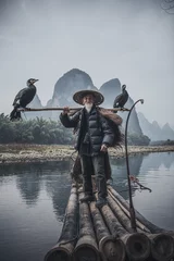 Cercles muraux Guilin A traditional cormorant fisherman works on the Li River Yangshuo, China.