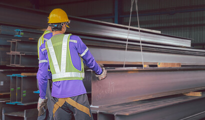 A male employee is preparing steel sections to be delivered to customers.