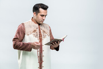 Ramadan, EIDMUBARAK, Portrait Asian Muslim man standing and reading the Quran and appreciates, The...
