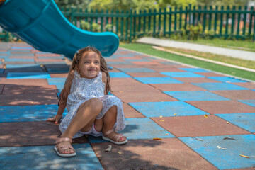 Happy girl playing alone in the floor of a playground