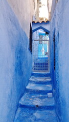 Steps leading to a grated entrance in the medina in Chefchaouen, Morocco