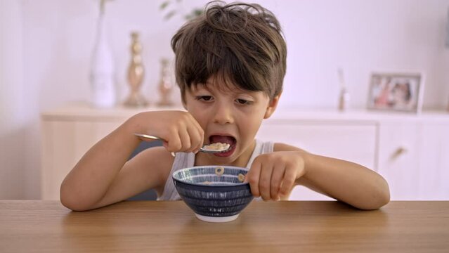 Little Boy Loves His Favorite Cereal With Milk In Bowl For Breakfast