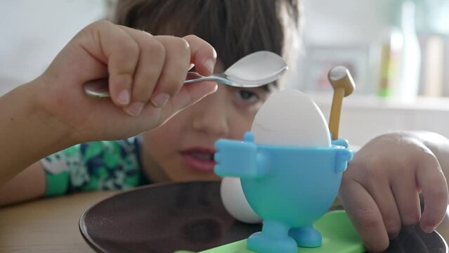 Little Boy Cracking Egg Shell In His Favorite Child-Friendly Holder During Breakfast