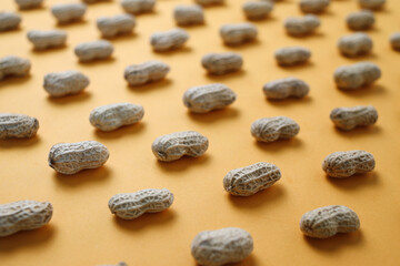 Fresh peanuts in shells forming seamless pattern on yellow background
