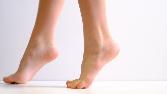 Barefoot, tiptoe legs, position, practicing in ballet studio, white background	