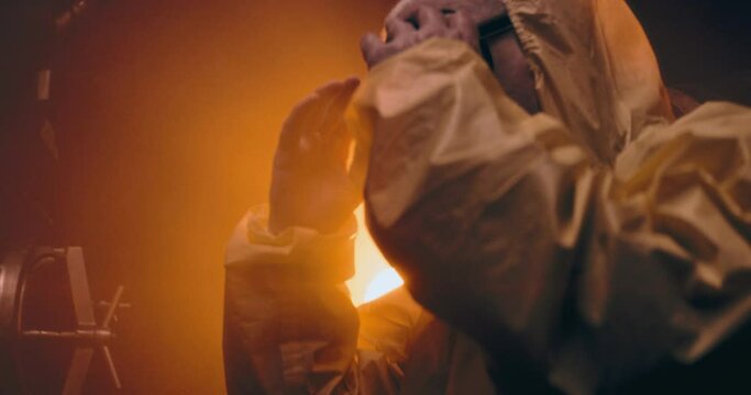 The video shows an elderly person in a protective suit and gas mask, standing in a dark room within a nuclear bunker, holding the bunker door. This scene captures the gravity of the nuclear aftermath 