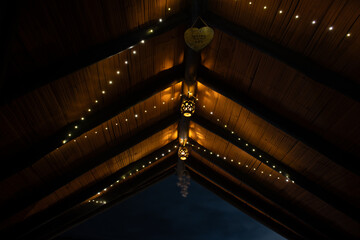 Wooden roof with a view of the night sky and clouds.