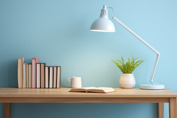 Simple light blue office interior with desk, books, wooden table with desk lamp and natural decorations. Modern house interior details. 
