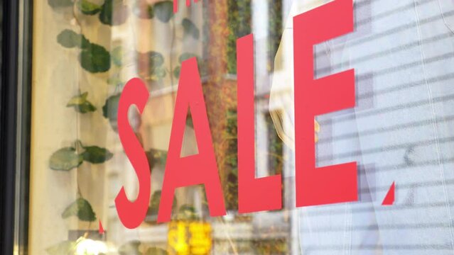 Large red Sale text letters on a glass wall obstruct a view inside the popular fashion store